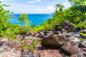 Fototapeta na wymiar Coastal mountain landscape with stone cairn on a sunny summer day. Seychelles