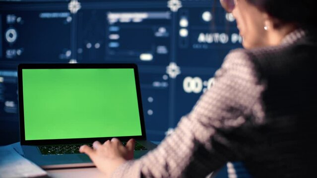 Muslim woman engineer working with laptop in modern office, closeup view of green screen of computer