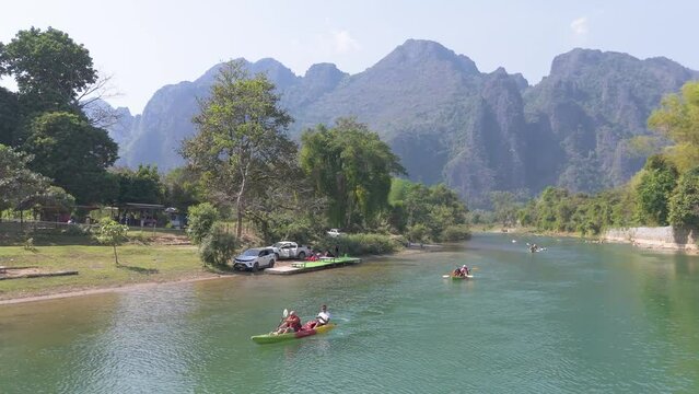 Tourists kayaking along the Nam Song river in Vang Vieng town, a tourist-oriented town surround with karst hill landscape in Vientiane Province, Laos.