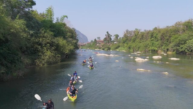 Tourists kayaking along the Nam Song river in Vang Vieng town, a tourist-oriented town surround with karst hill landscape in Vientiane Province, Laos.