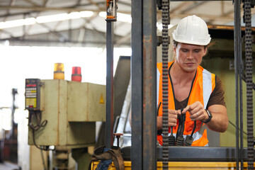 male factory worker control and holding steering wheel on forklift truck