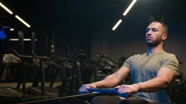 Sport workout in gym exercise with rowing machine simulator sitting dead lift low row in sportive club effort goals motivation health African American man sporty male guy athlete sportsman bodybuilder