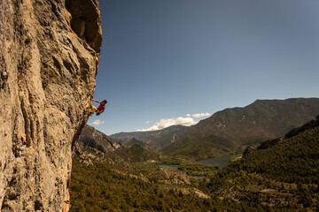A man is climbing a rock wall in the mountains