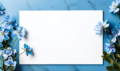 Beautiful work decorated with a blank page and blue flowers on a white marble top view. Copy-space, place for your lettering. 