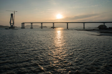 Obraz premium constructing the bridge on the sea during sunset