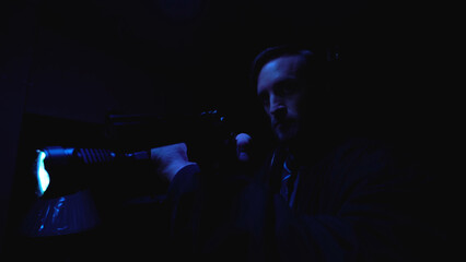 Fototapeta na wymiar Male security guard examines a dark warehouse with a handgun and flashlight, facing danger 
