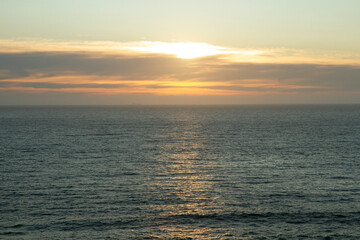 Seascape. Panorama view of the hiding sun and ocean weaves at sunset