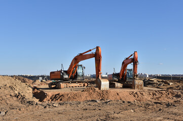Construction site. Excavator on groundwork. Backhoe dig foundation for house construction. Building...