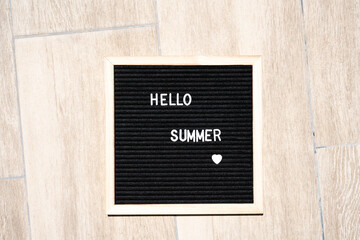 Hello summer text on chalkboard on pool background on summer sunny day.