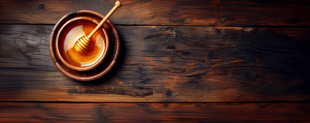 Bowl of honey with dipper on dark wooden table, rustic simplicity with rich tones. Top view showing textures and wood grain
