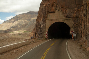 Travel. Asphalt highway in the Andes mountains on the road to mountain Aconcagua in Mendoza, Patagonia Argentina. The road crosses a tunnel in the rocky hill