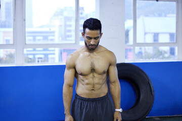Asian man, shirtless and sweat for workout in gym, serious and athlete for strength training. Male person, tough and abs of bodybuilder for power or fitness challenge, sports and cardio for health