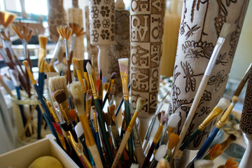 a set of painting brushes and some wooden structure rollers