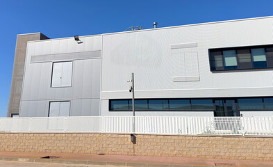 Warehouse exterior building. Construction of a warehouse for storage of goods and provision of logistics services. Logistics warehouse with gate and fence. Facade of factory exterior building