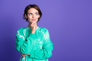 Photo portrait of attractive young woman touch chin look empty space dressed stylish green clothes isolated on violet color background