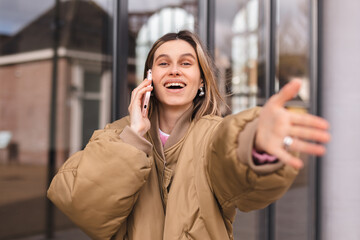 Beautiful brunette young woman have mobile phone call talk looking at the camera smiling with open...