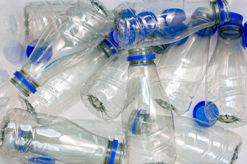 Background of many used empty PET water bottles, top view.