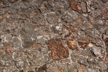 Stone texture of a wall in Montenegro. An ancient wall made of brown coloured stones. Background. Template. For design. Horizontal. - obrazy, fototapety, plakaty