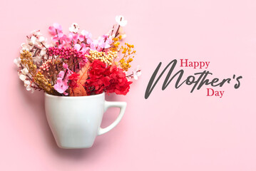 Happy Mother's Day. White cup of coffee with various flowers and the text Happy Mothers day