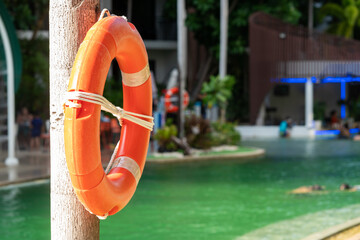 A lifebuoy hangs on the side of the swimming pool. - obrazy, fototapety, plakaty
