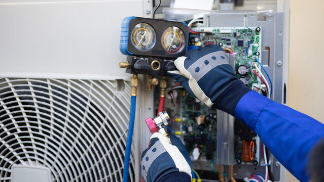 Close up Air conditioner's technician hand check  fill refrigerant liquid and maintenance condensor unit, Home care service