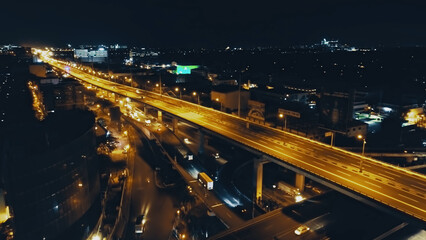Night closeup traffic road with cars, trucks drive at night top down aerial view. Philippines capital town of Manila highway with transport ride at neon lights. Amazing illuminated cityscape drone - obrazy, fototapety, plakaty
