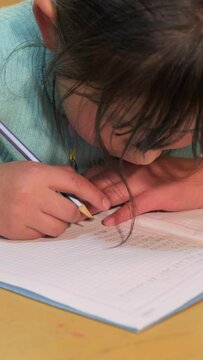 latina girl writing with a pencil on a piece of paper - education concept