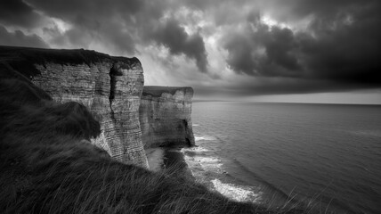 Black and white photography of the cliffs and seascape, dark with clouds. Landscapes photography