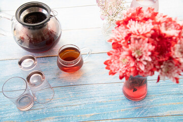 still life with a glass of tea and flowers - obrazy, fototapety, plakaty