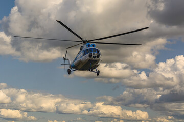An Mi-8 passenger helicopter flying. Blue cloudy sky in the background