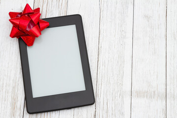 An ereader with gift bow on a old weathered table