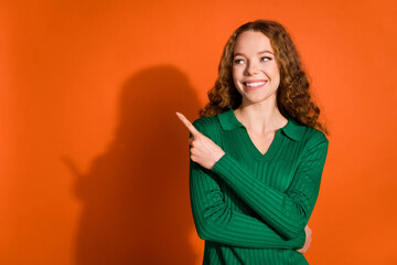 Photo of shiny dreamy lady dressed green shirt showing finger looking empty space isolated orange color background