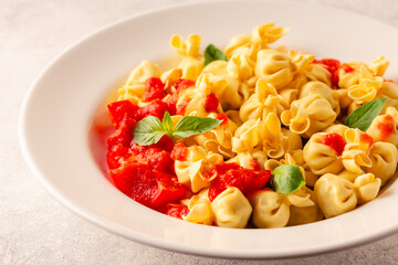 Sacсhettini pasta in a plate with tomato sauce. - 789507695
