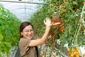asian woman looking at big butterfly at summer farm