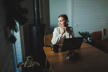 Home of young woman studying and drinking coffee while sitting at table with laptop and laptop at home - obrazy, fototapety, plakaty
