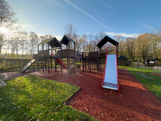 Colorful playground with climbing stairs and slides on yard in the park.  - obrazy, fototapety, plakaty