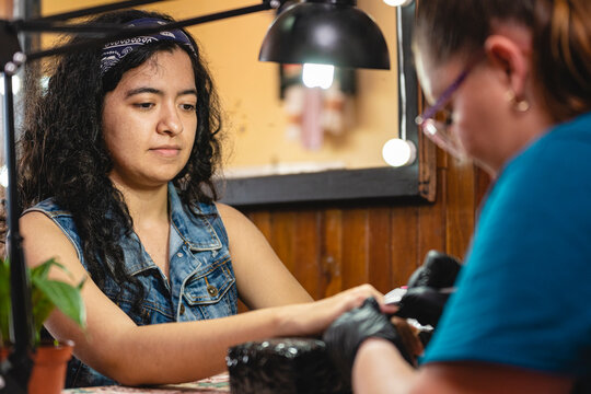 Woman being attended by the manicurist.
