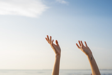 Two hands of anonymous woman trying to touch the sky