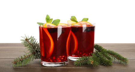 Aromatic Christmas Sangria drink in glasses and fir branches on wooden table against white...