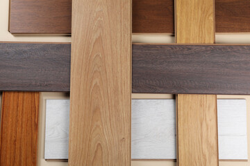 Different samples of wooden flooring on beige background, flat lay
