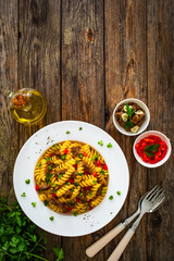 Pasta with roasted pork meat - noodles witch pork cheeks and vegetables on wooden background
