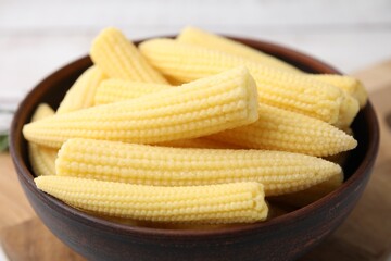 Tasty fresh yellow baby corns in bowl on table, closeup