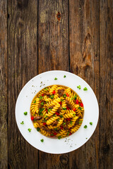 Pasta with roasted pork meat - noodles witch pork cheeks and vegetables on wooden background
