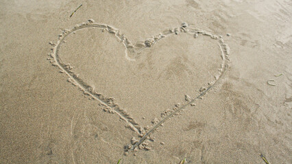 Heart drawn on a sandy beach,  - obrazy, fototapety, plakaty