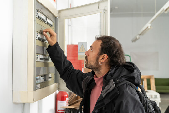 man turn off electrical panel