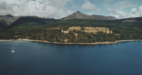 Scotland mountain Goatfell landscape aerial panoramic view at Brodick Harbour, Arran Island. Majestic Scottish nature scenery of forests, meadows and medieval castle.