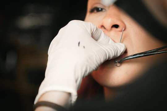 Woman giving a piercing to woman