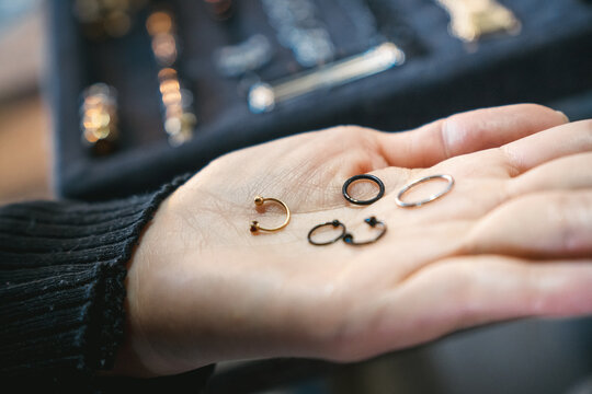 Woman holding piercing jewelry