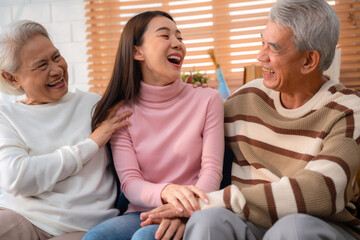 Asian Family Bonds: Daughter's Laughter Echoes in the Home as Grandfather and Grandmother Enjoy...