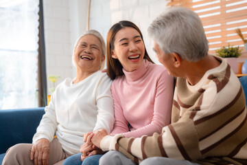 Asian Family Bonds: Daughter's Laughter Echoes in the Home as Grandfather and Grandmother Enjoy Retirement, Sharing Hugs and Smiles on the Sofa, A Precious Elderly Bonding Moment